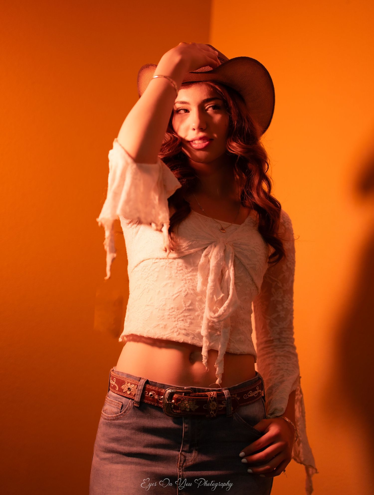 Fashion shoot sequence with orange background showing western-inspired styling.