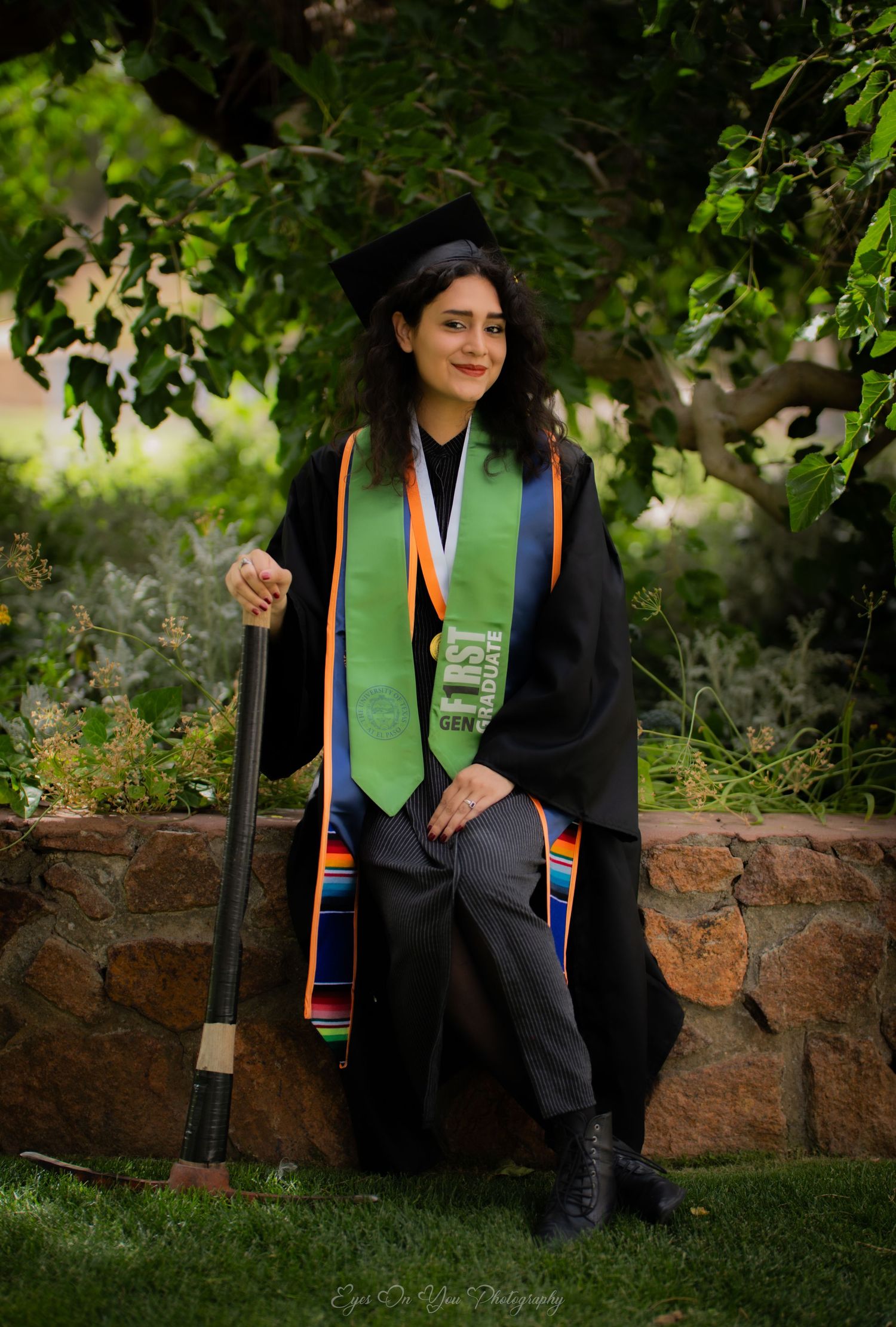 Graduation photo series in a garden setting with colorful graduation stoles.