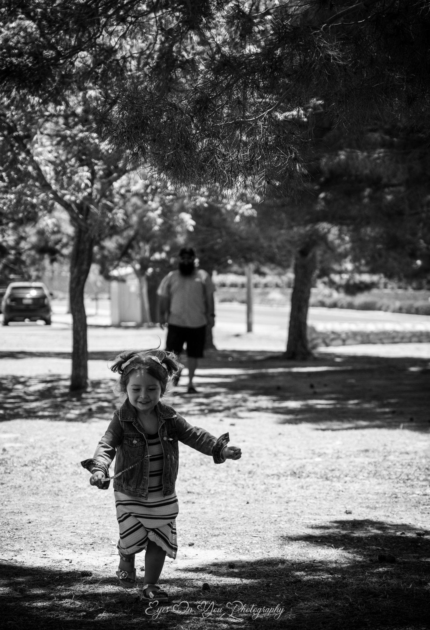 Black and white photo sequence of a toddler walking in a park under trees.