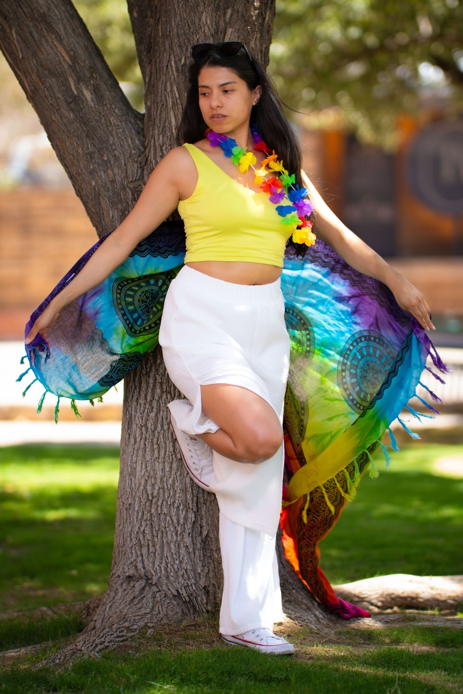 Festive dance poses around a tree with rainbow-colored costume details.