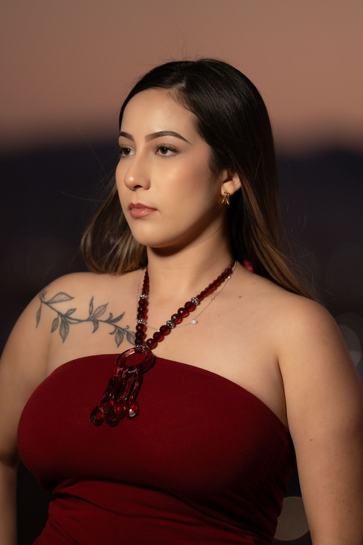 A series of portrait photos showing someone in a burgundy halter top against a dusky sunset background.