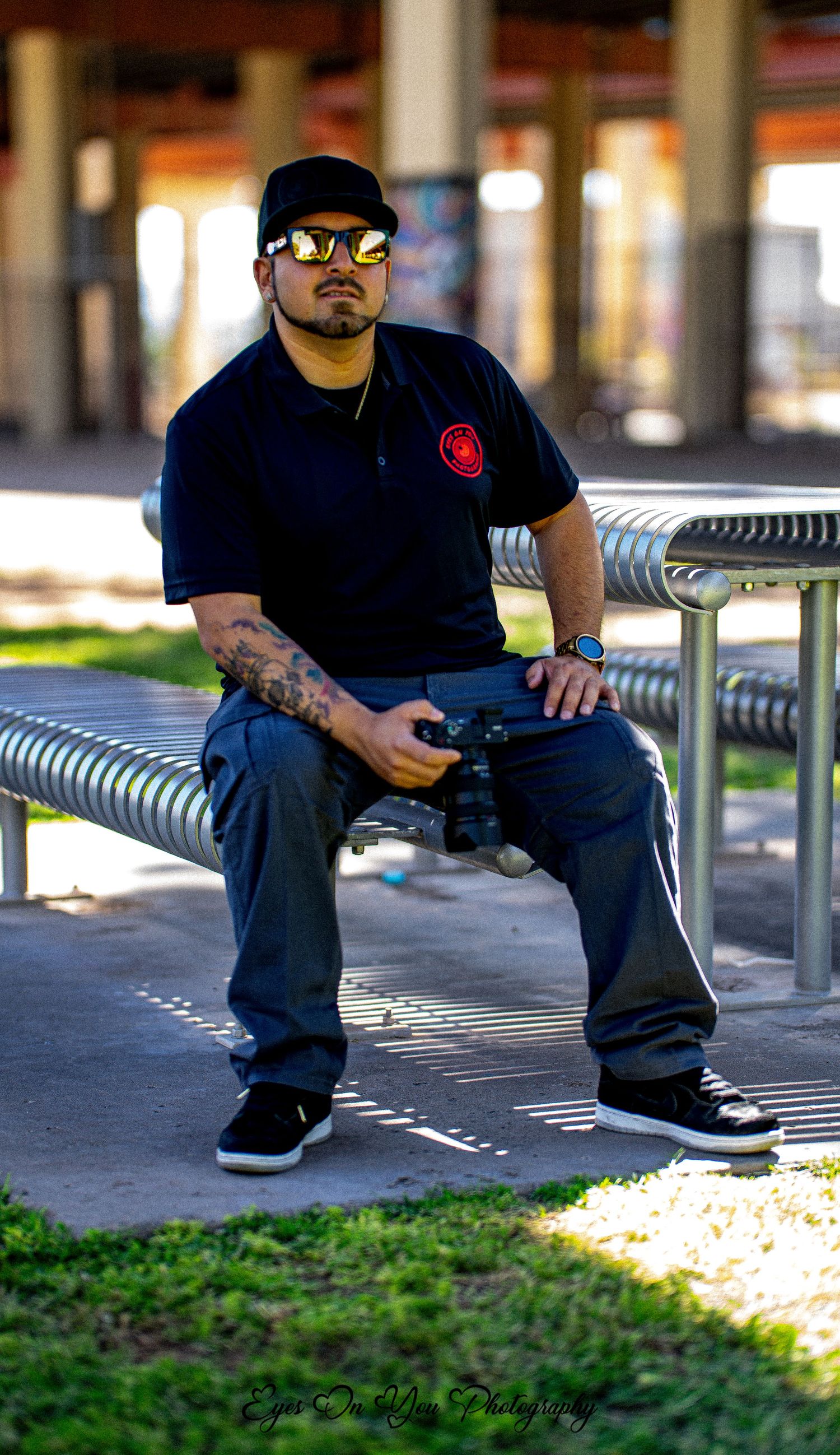 Person in navy attire sitting on metal bench in urban setting.