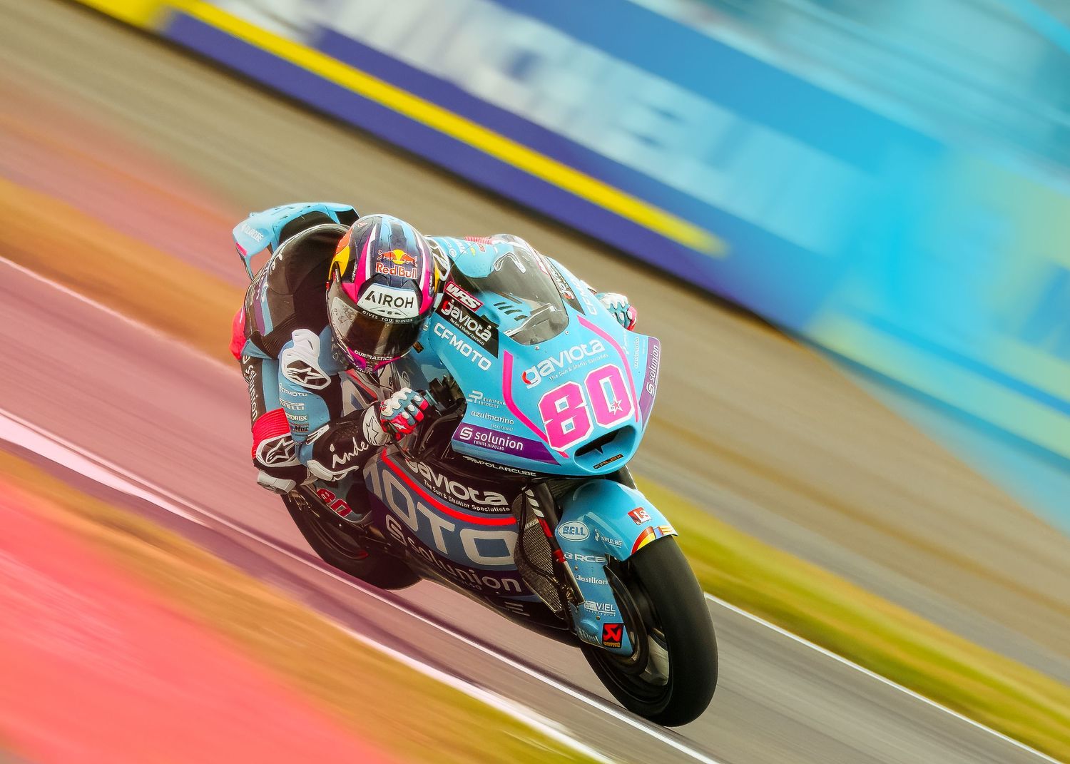 David Alonso blurs past on a colorful Silverstone Setting during Moto2 Race.