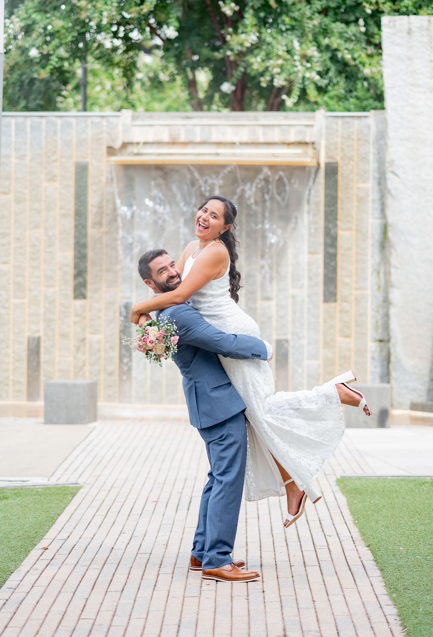 Beautiful couple after their elopement wedding in Charlotte NC. Bride wearing simple white dress while groom wears gorgeous blue suit.