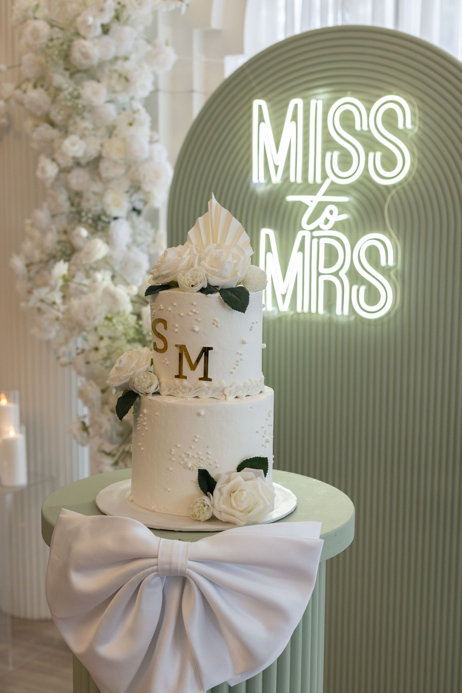 This image shows the event backdrop, decor and cake at a bridal shower.