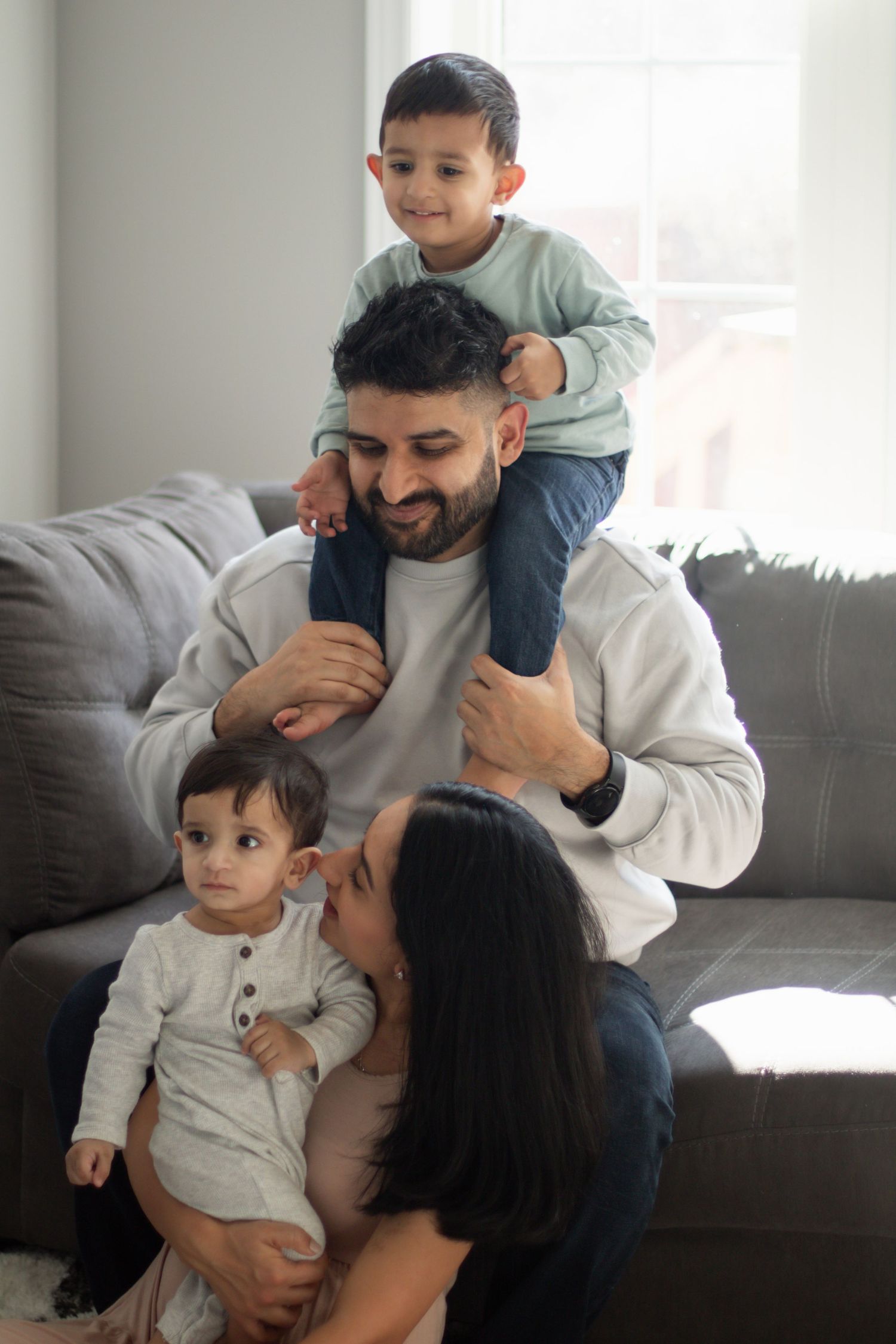 This image shows a family of four gathered around their couch.