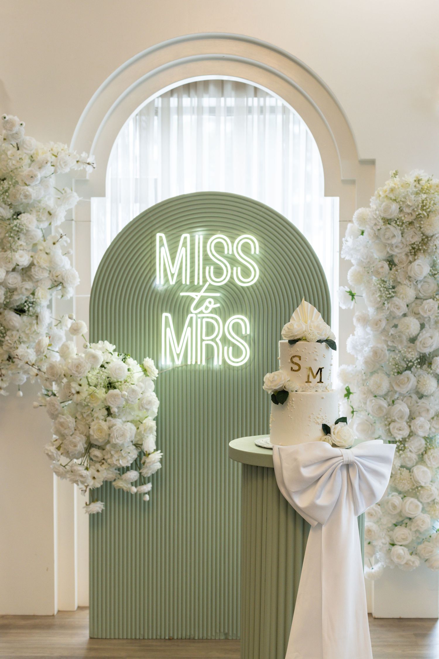 This image shows the event backdrop, decor and cake at a bridal shower.