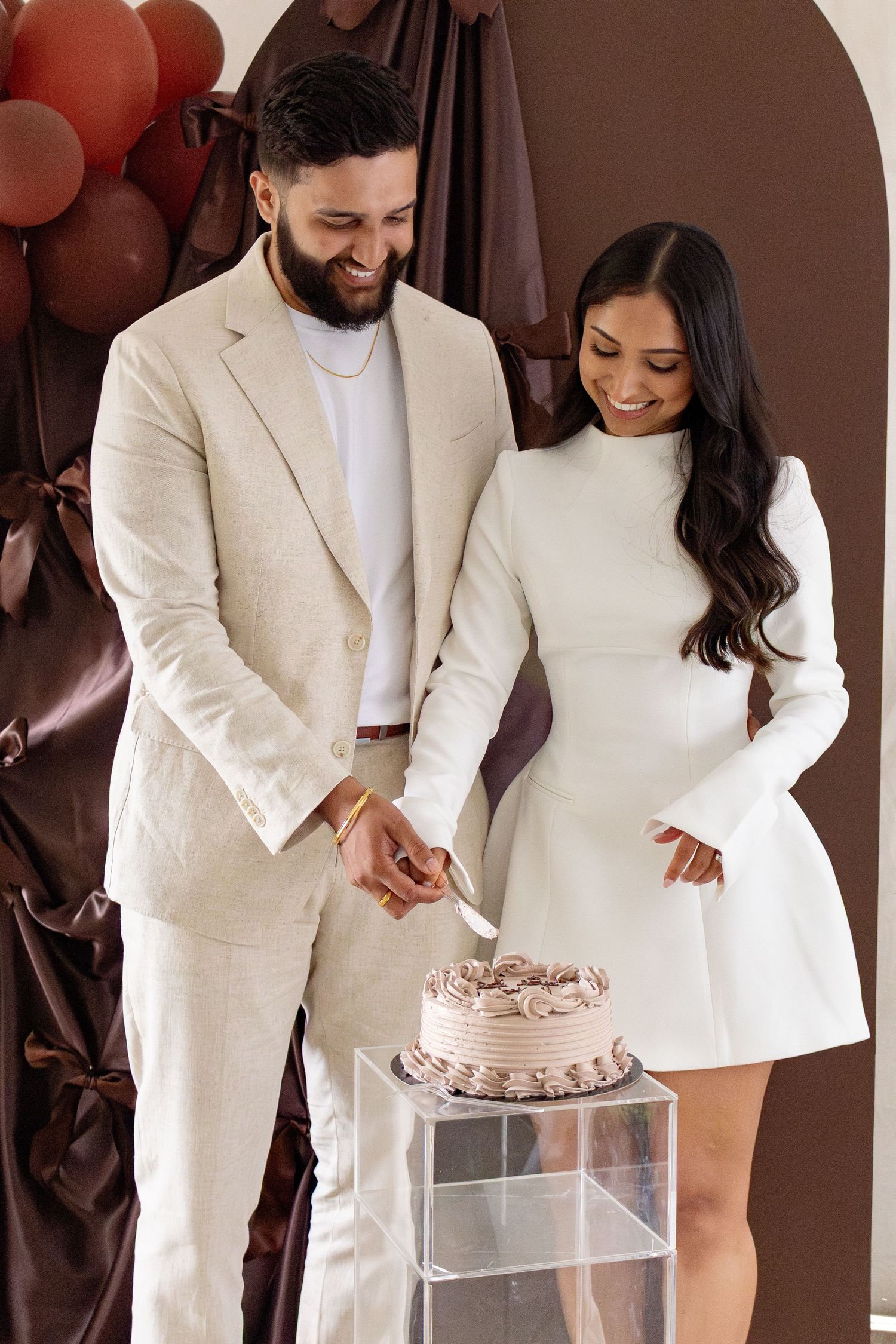 This image shows a couple cutting a cake at a bridal shower.