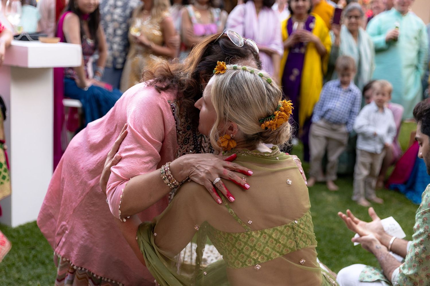 Wedding party dancing and celebrating outdoors in pink and pastel attire.