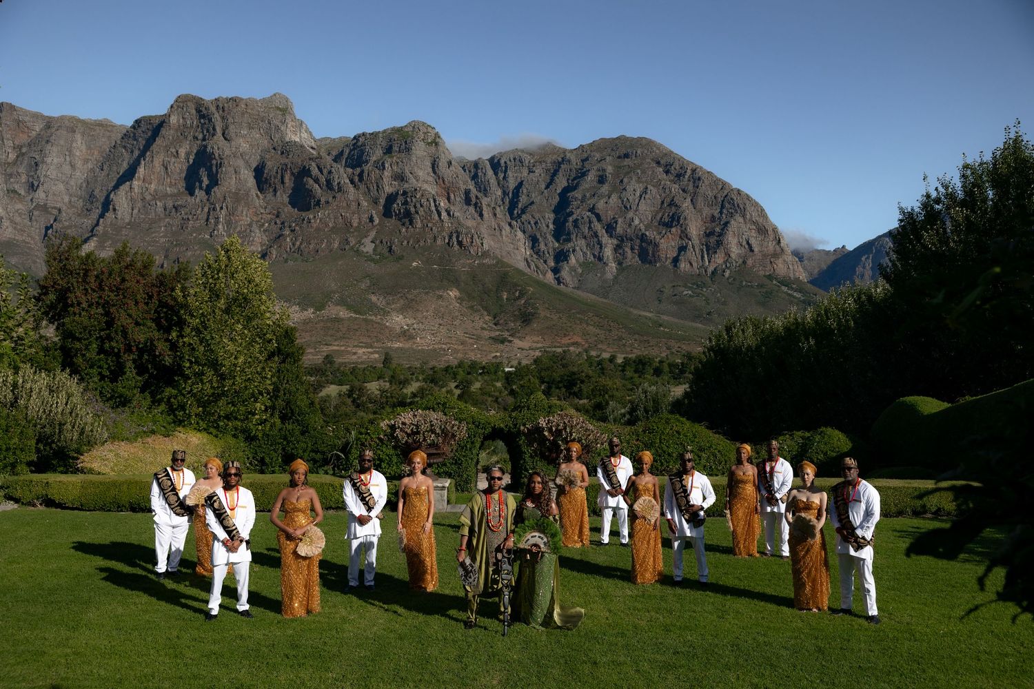 Group gathering on a lush green lawn with majestic mountains forming a stunning natural backdrop.