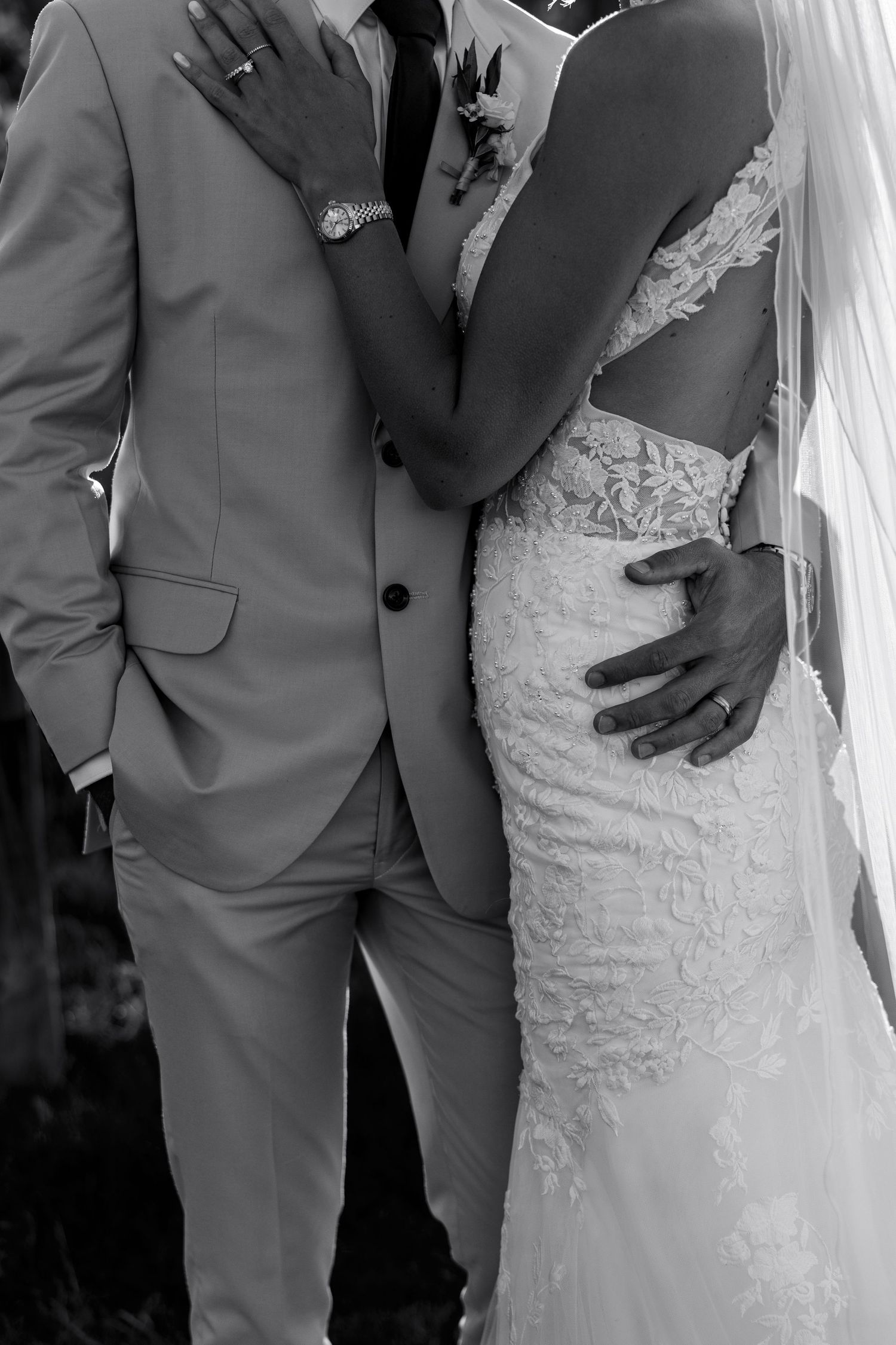 Black and white wedding photo series showing intimate close-up details of a bride in lace gown with groom in light suit.