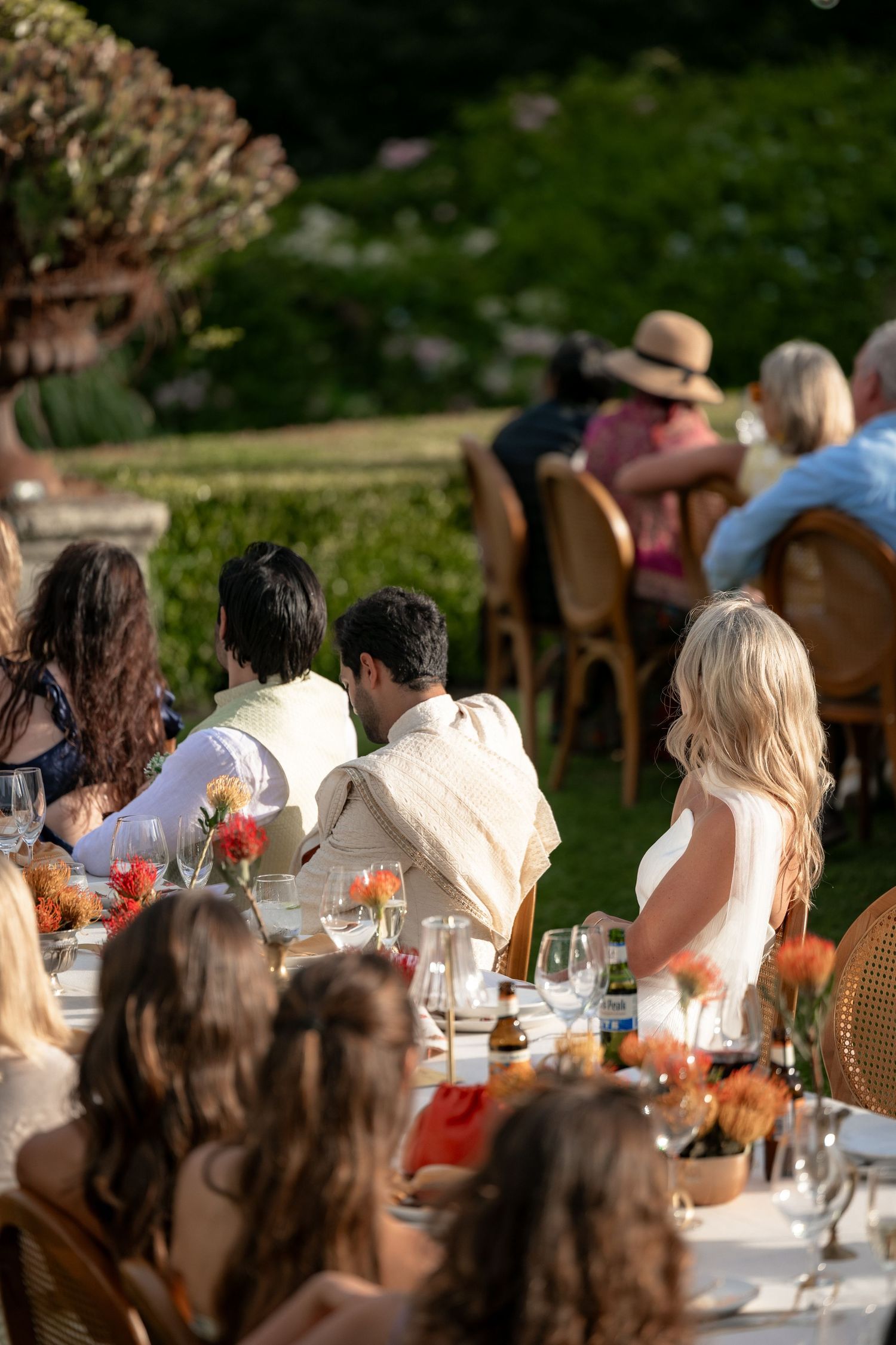 Wedding guests seated at long tables during an outdoor celebration.