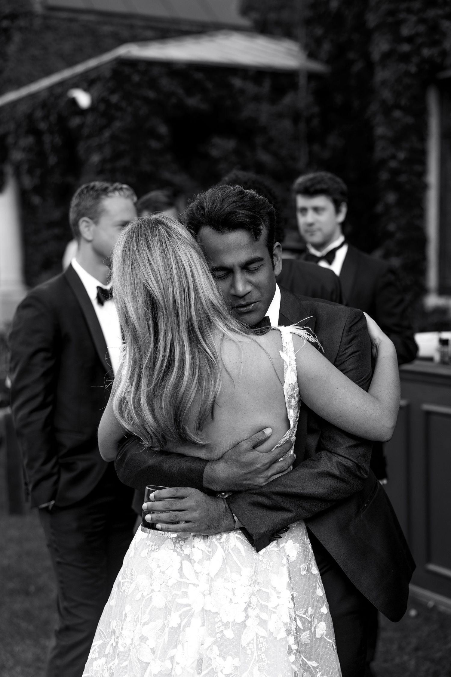 A couple shares an intimate dance moment at a formal event in black and white photography.