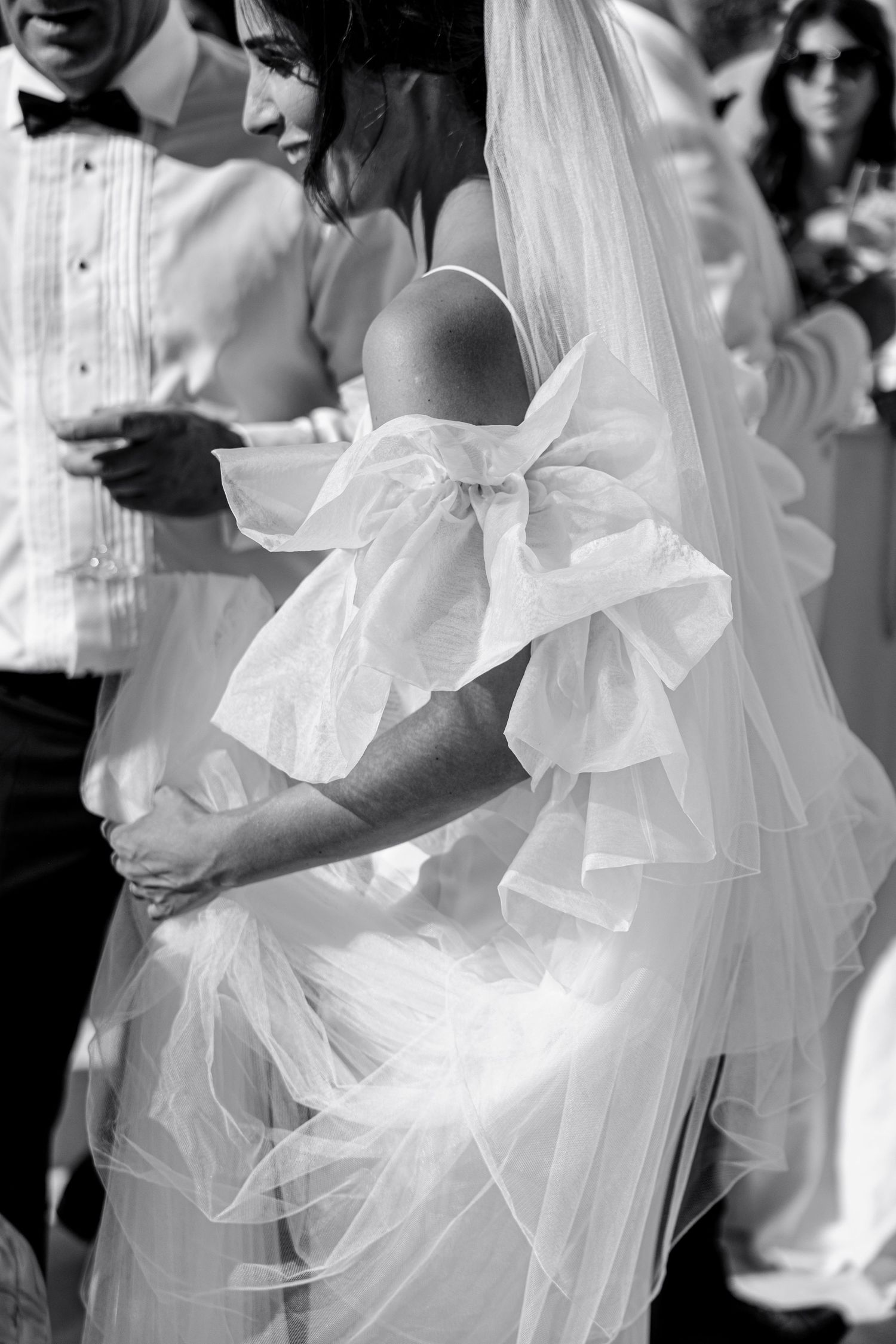 Black and white wedding photos showing close-up details of a flowing white bridal veil and dress.