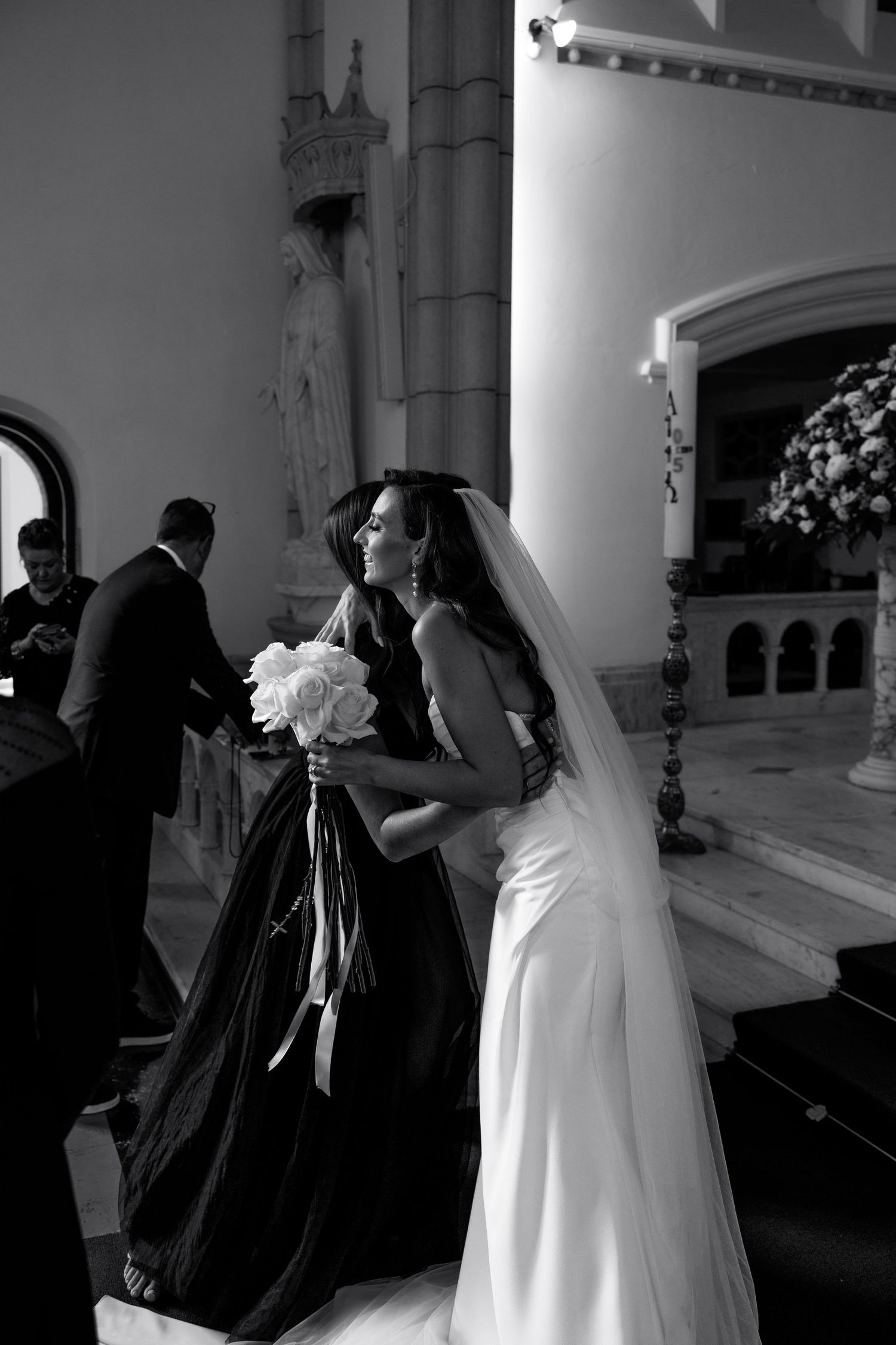 Black and white photo of wedding ceremony preparations in ornate church interior.