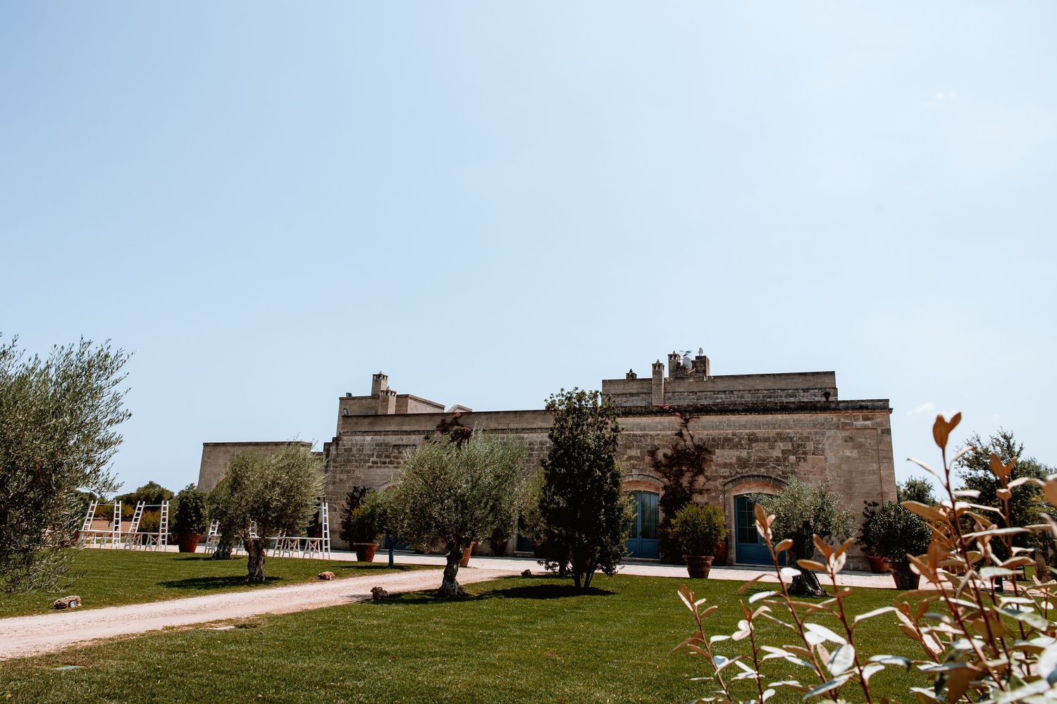 Panoramic view of a rustic stone building venue with olive trees in the Italian countryside.