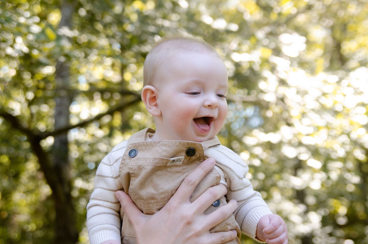 Outdoor baby photography session in Charlotte, NC capturing natural expressions and laughter.