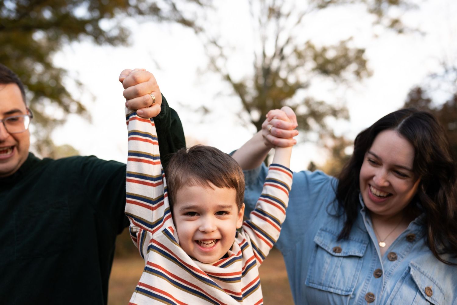 Parents lifting their young child during a outdoor lifestyle family photography session in Charlotte, NC.