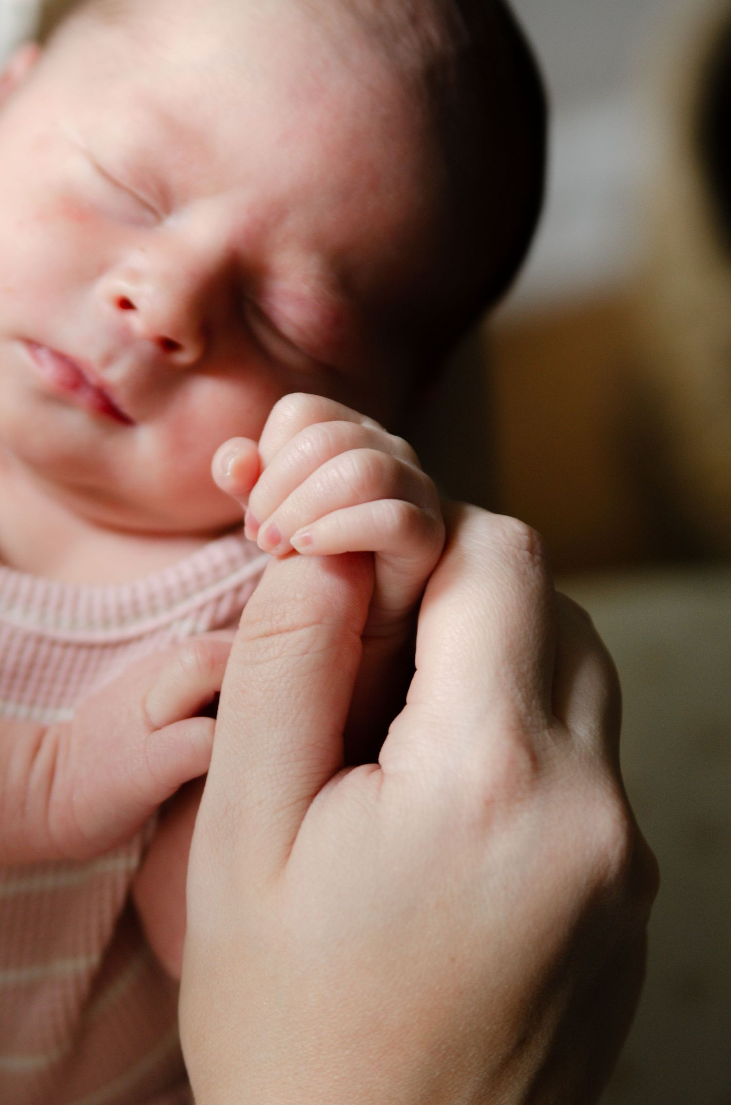 Close-up of baby fingers grasping during a lifestyle newborn photography session in Charlotte, NC.