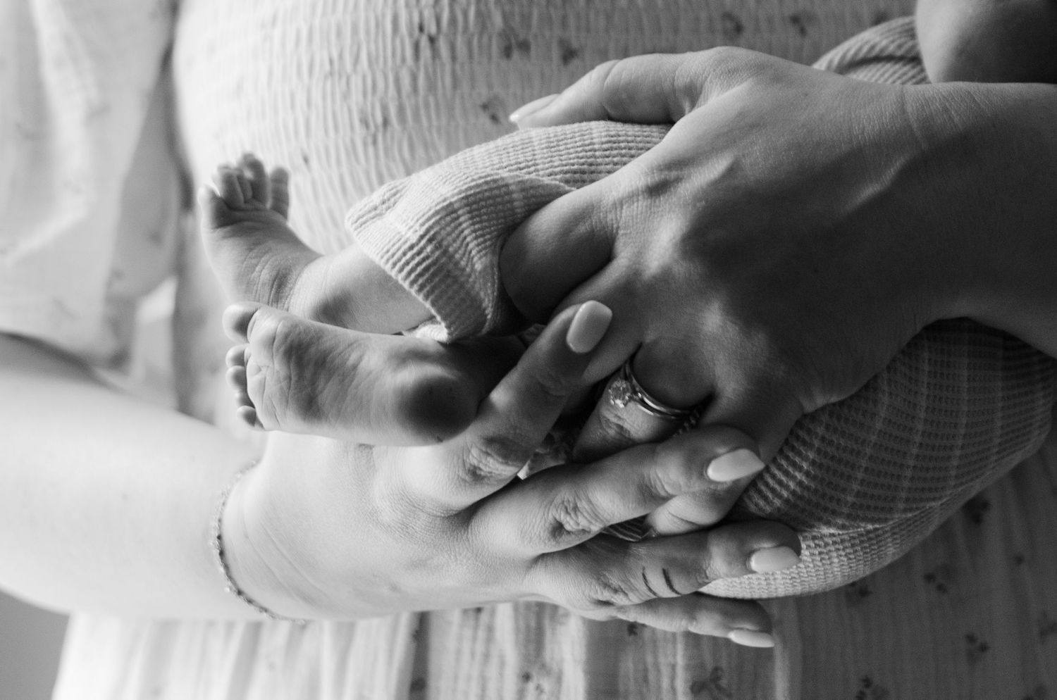 Black and white close-up of hands holding during a lifestyle family photography session in Charlotte, NC.