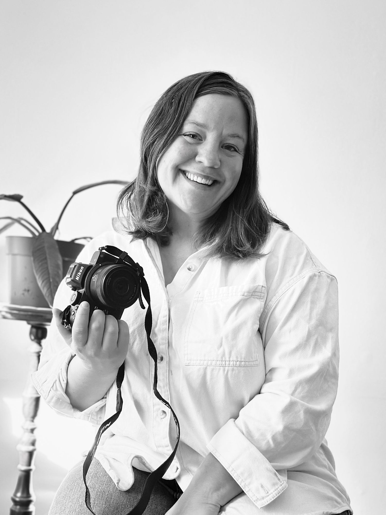 A series of black and white portraits showing someone in a white shirt holding a camera against a white background.