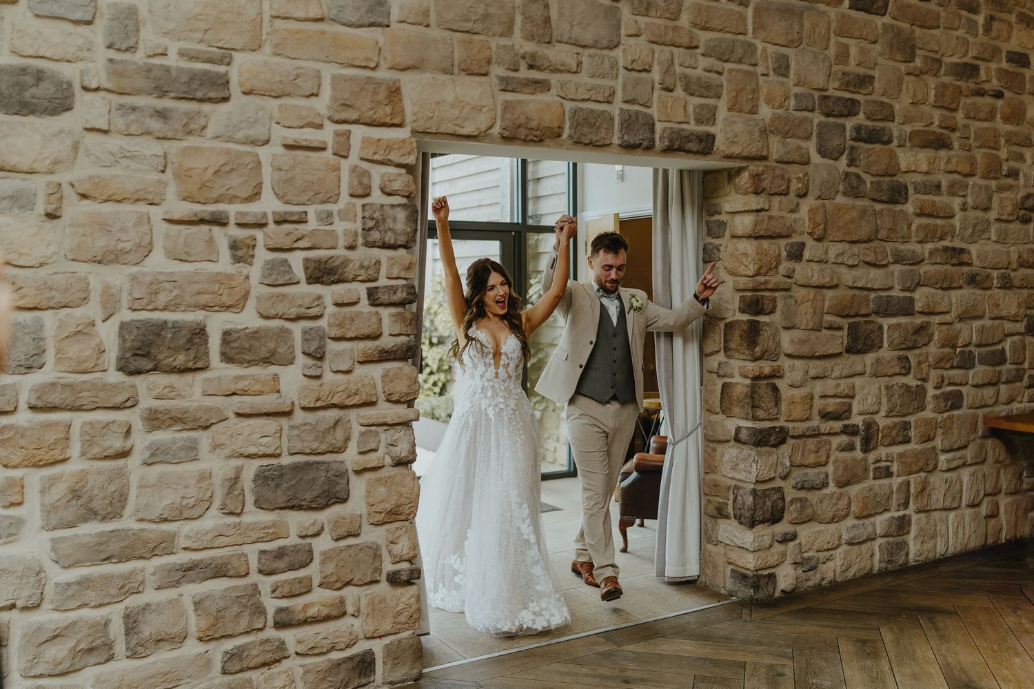 Interior of rustic stone-walled venue decorated for an elegant wedding celebration.