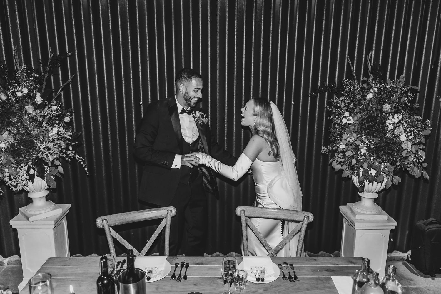Wedding reception venue with modern black and white decor and floral arrangements.