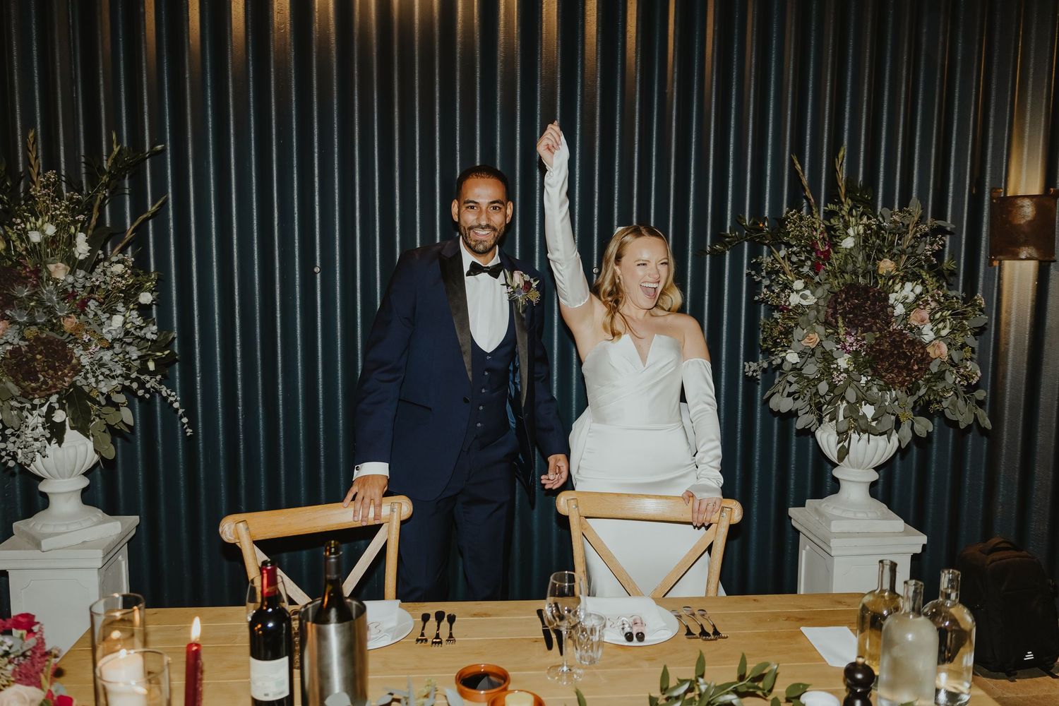 Wedding reception venue decorated with elegant table settings and vertical striped black walls.