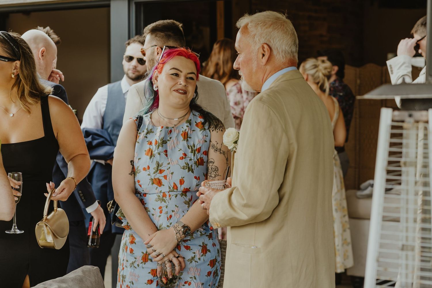 Wedding guests mingle and chat during outdoor reception celebration.
