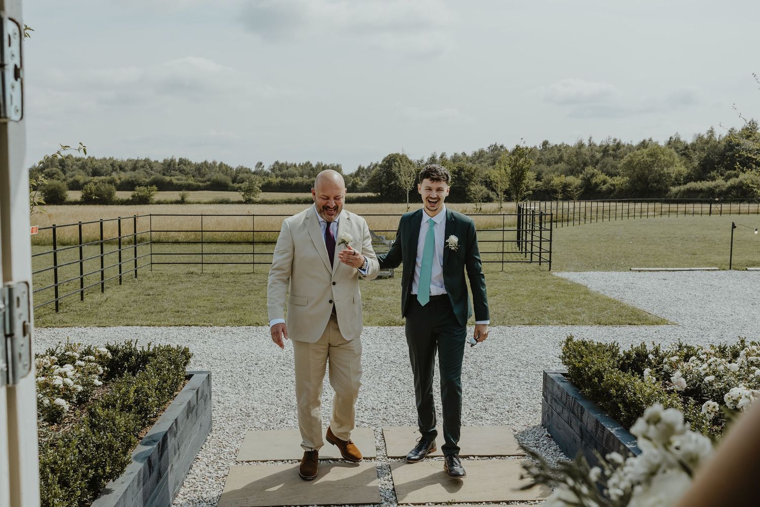 Outdoor wedding venue with rolling hills and fenced pastures in the background.