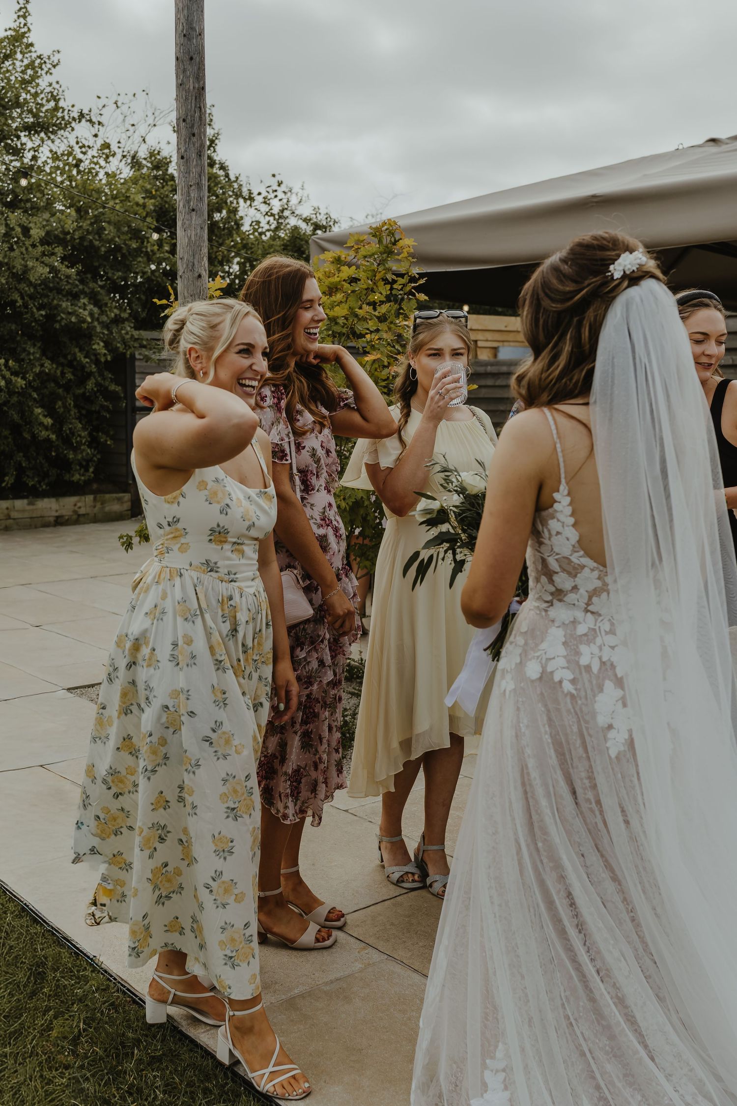 Wedding party members gather outdoors sharing emotional moments before the ceremony.