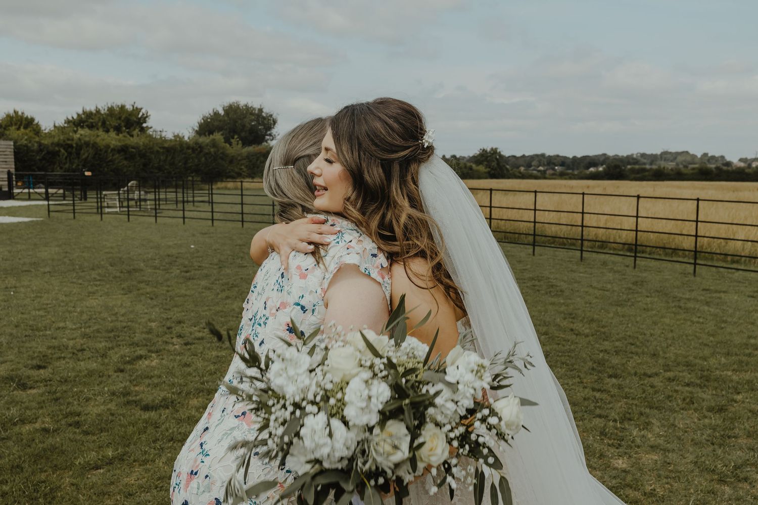 Elegant wedding ceremony setup outdoors with floral arrangements and seating on a grassy field.