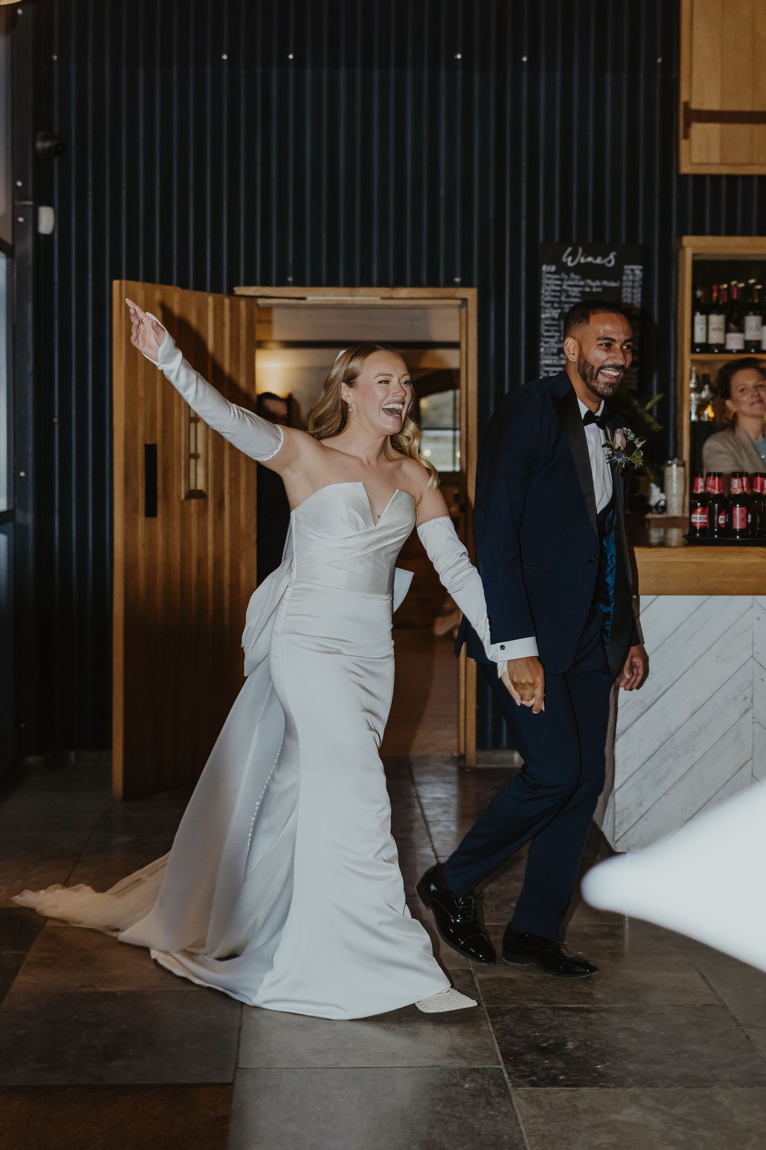 Joyful entrance of newlyweds at their wedding reception venue.