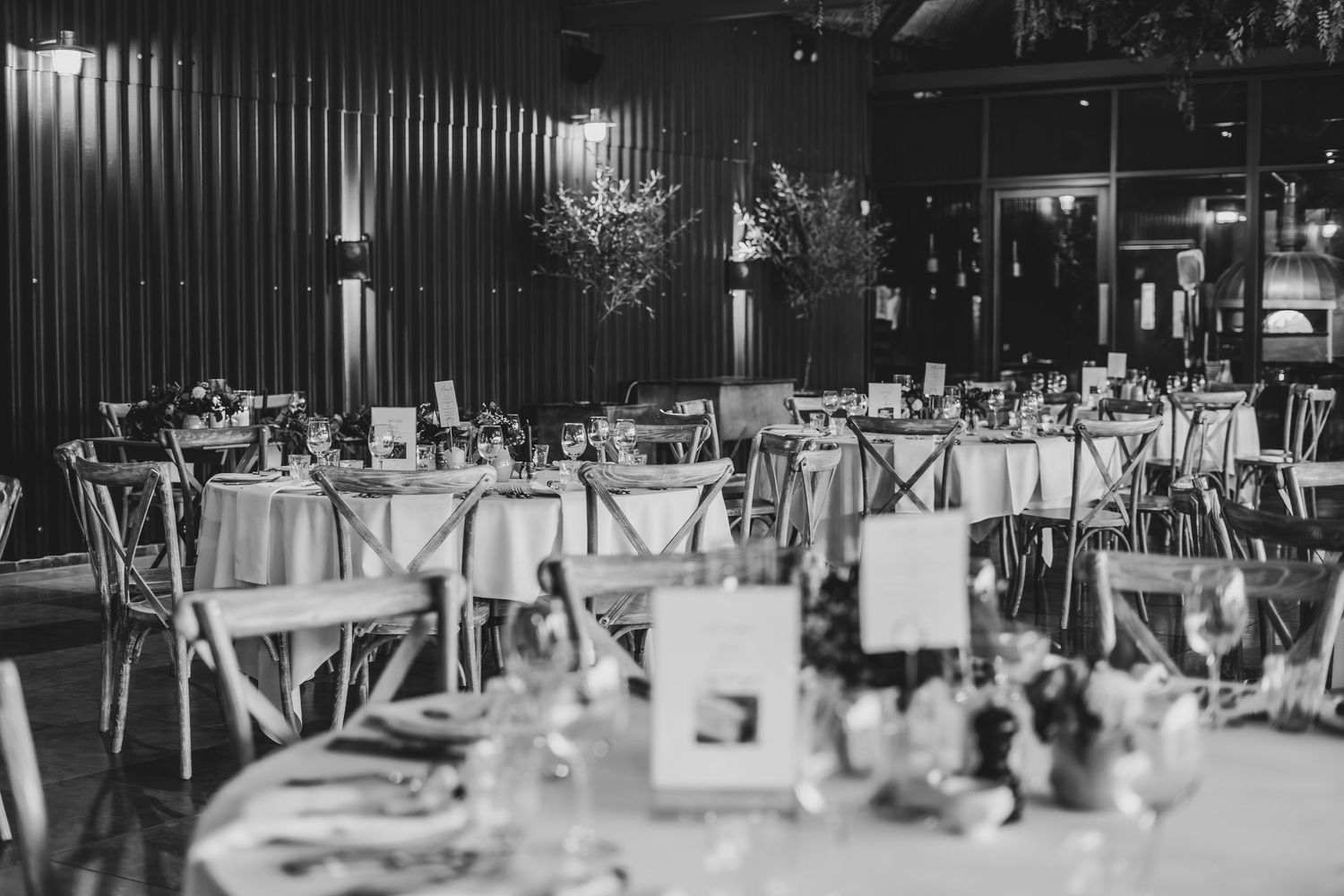 Black and white photo of an elegant wedding reception setup with round tables.