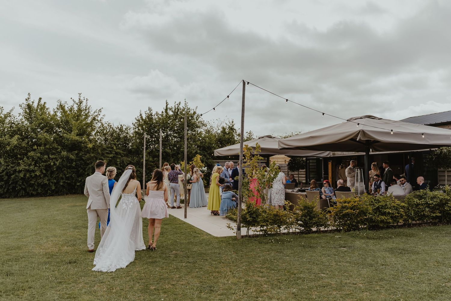 Panoramic view of an outdoor wedding venue with string lights and reception setup.