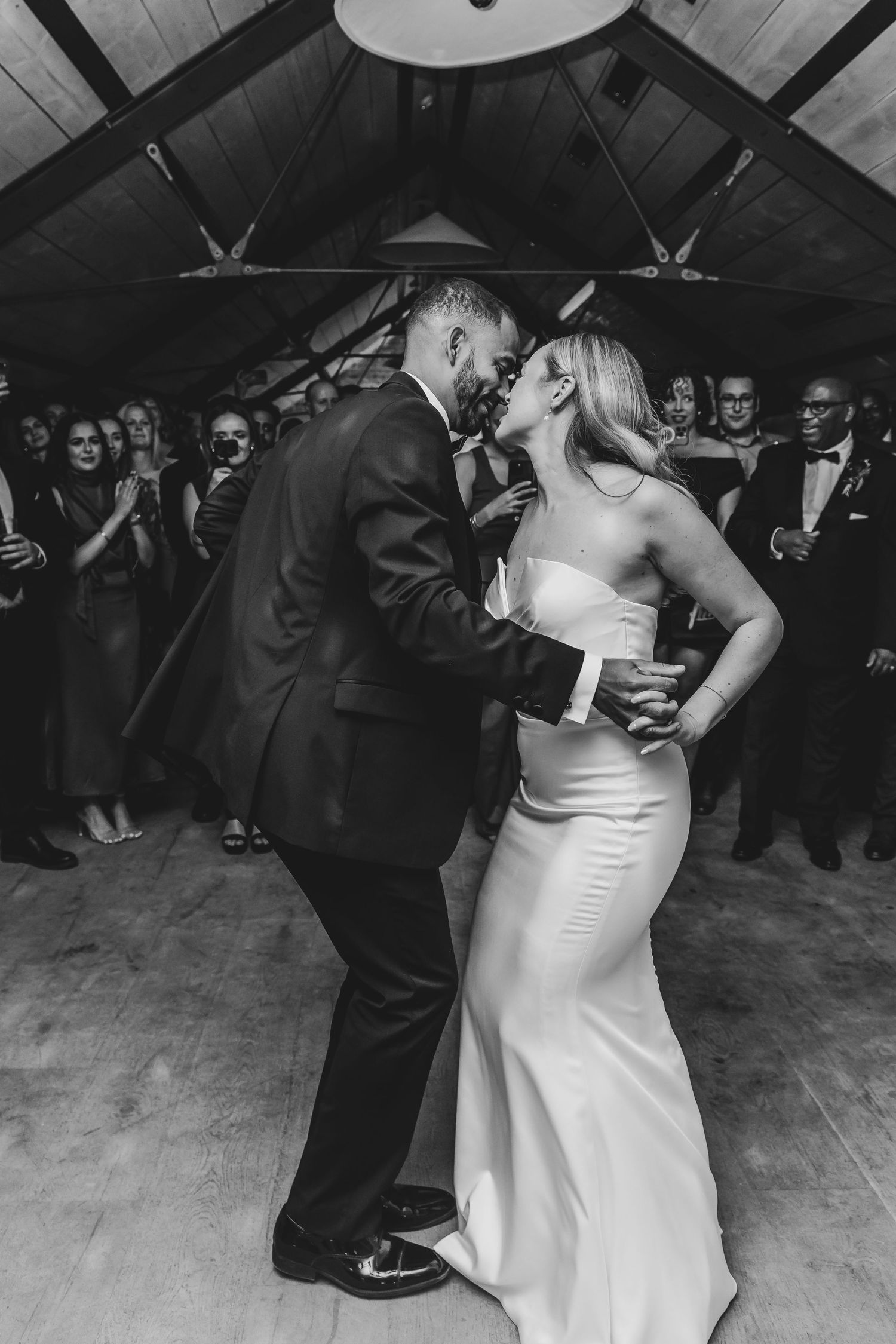 Black and white photo of a couple dancing closely at their wedding reception.
