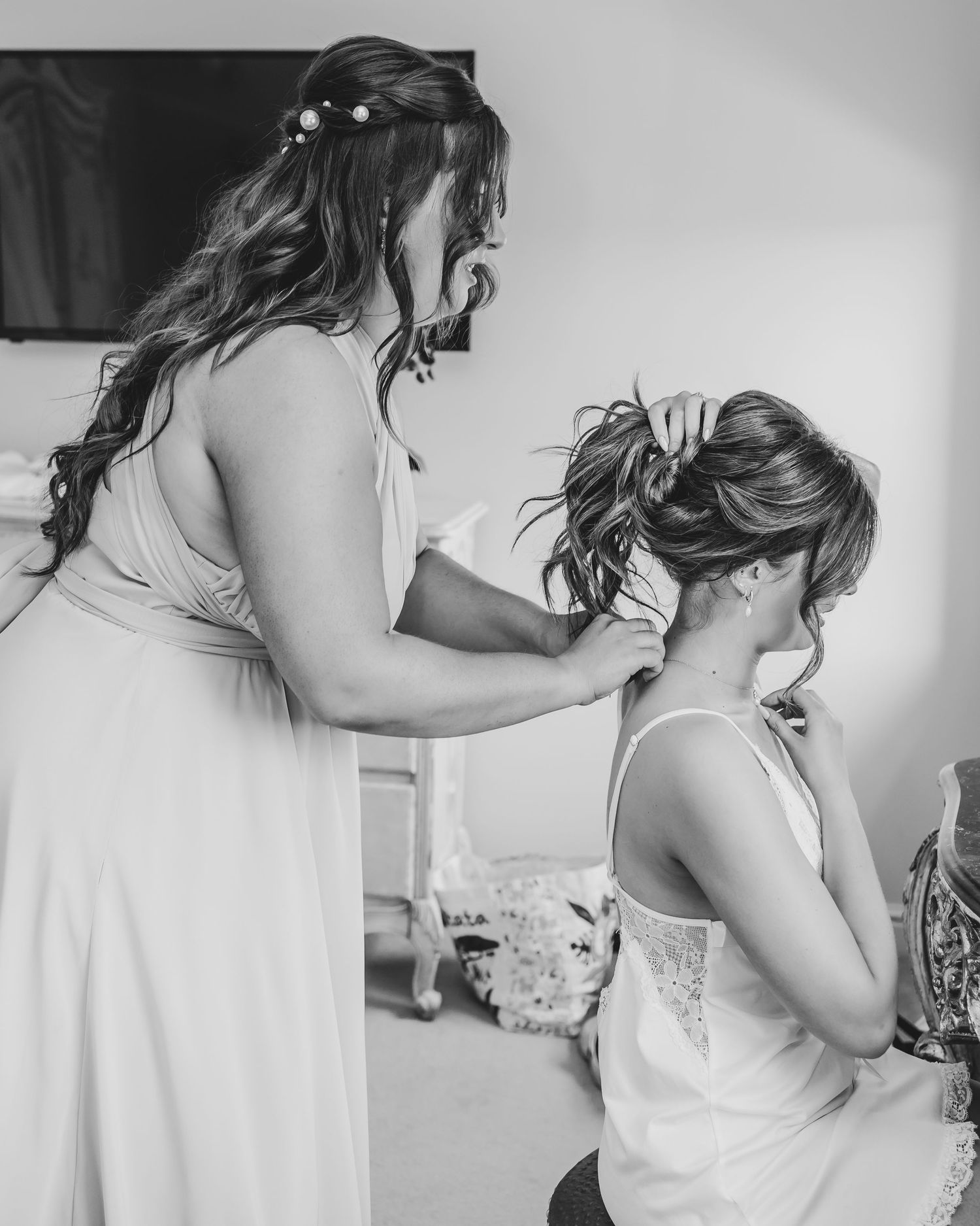 Black and white image showing someone adjusting their jewelry.
