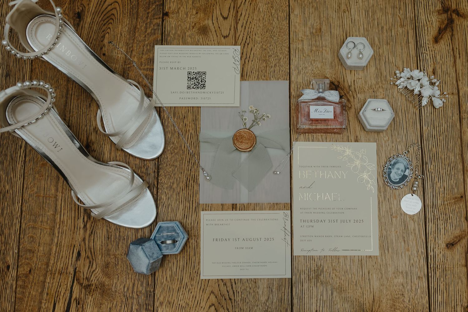 Wedding invitation details and decorative elements arranged on a rustic wooden surface.