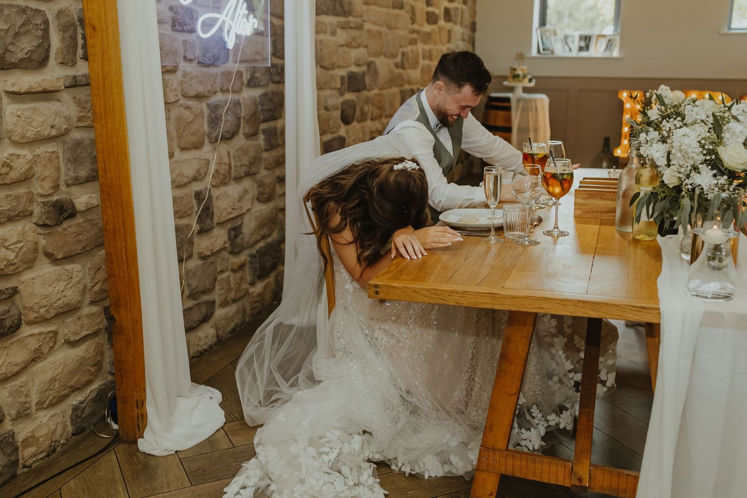 Intimate wedding reception setup with stone walls and elegant table decorations.