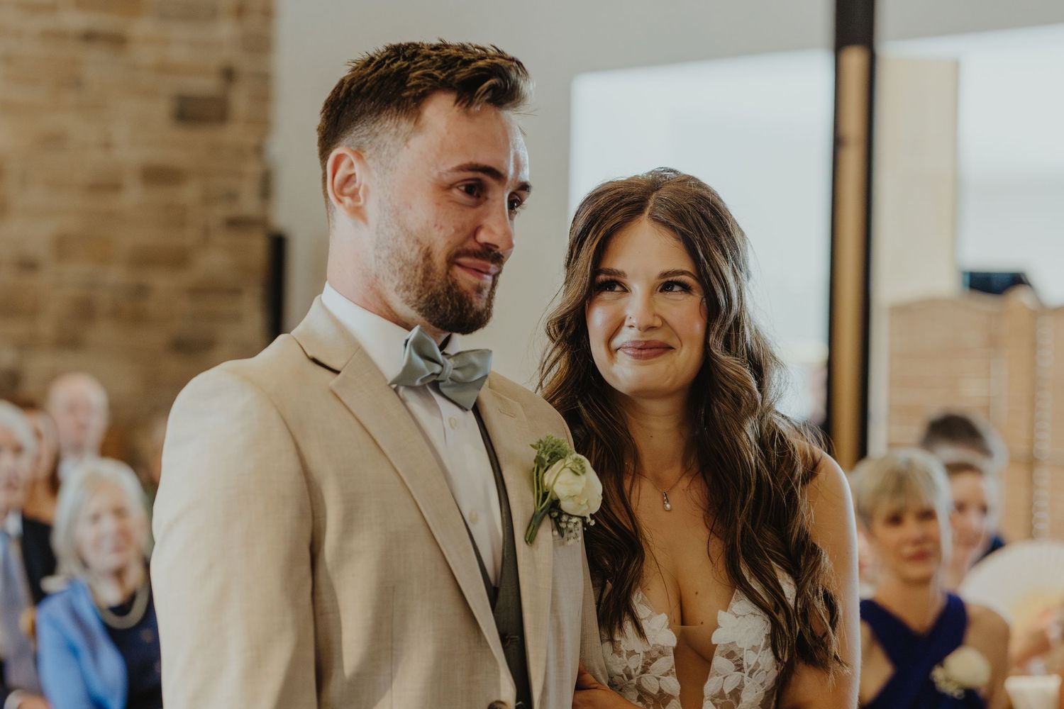 Wedding couple celebrating during their ceremony in a rustic brick venue.
