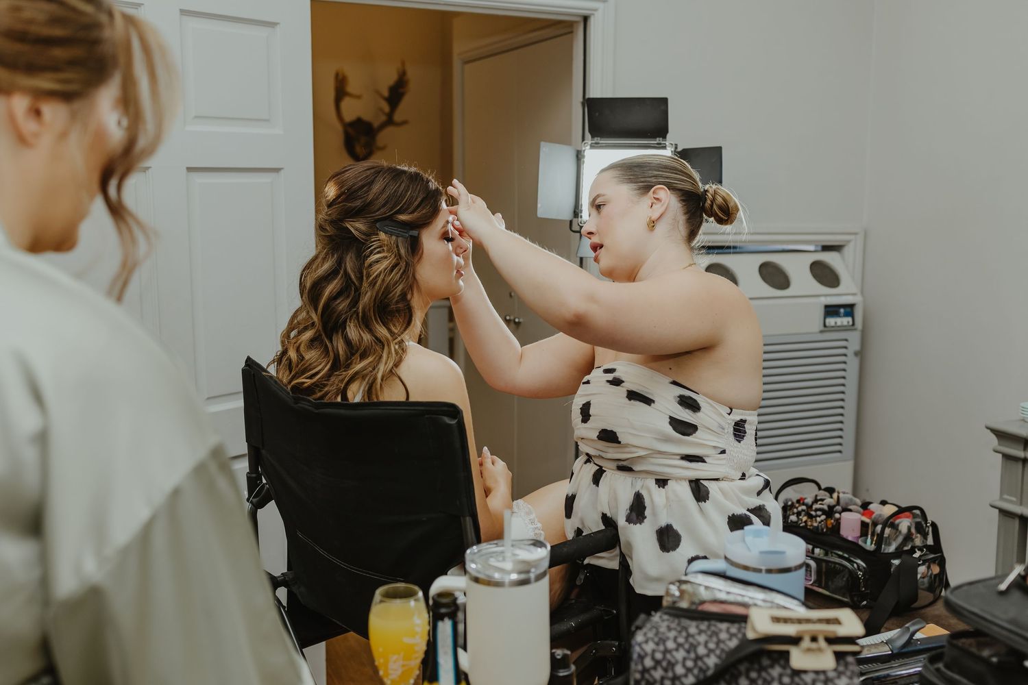 Getting ready scene with styling products and mimosas on counter.