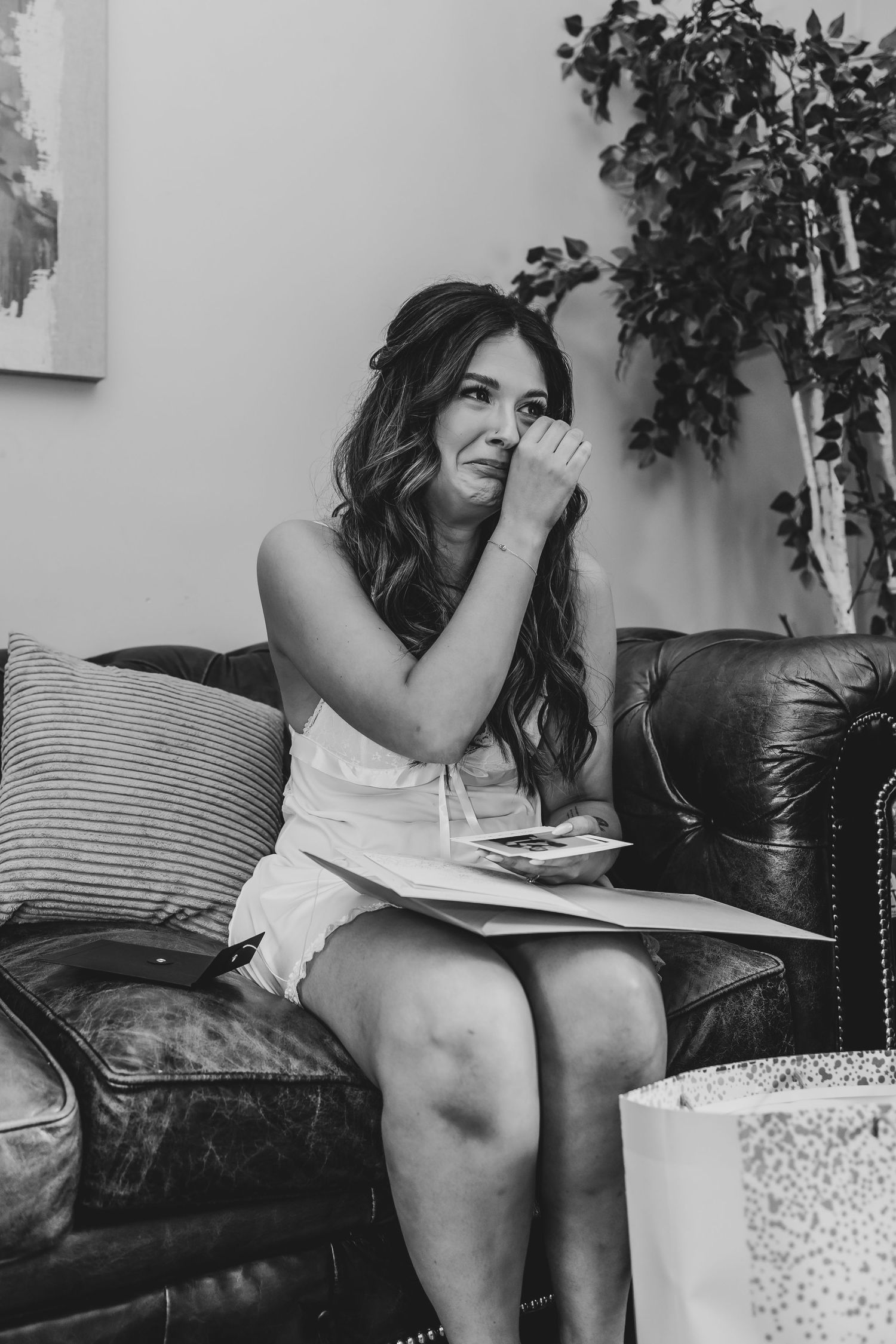 Person sitting on leather couch looking at something with joy.