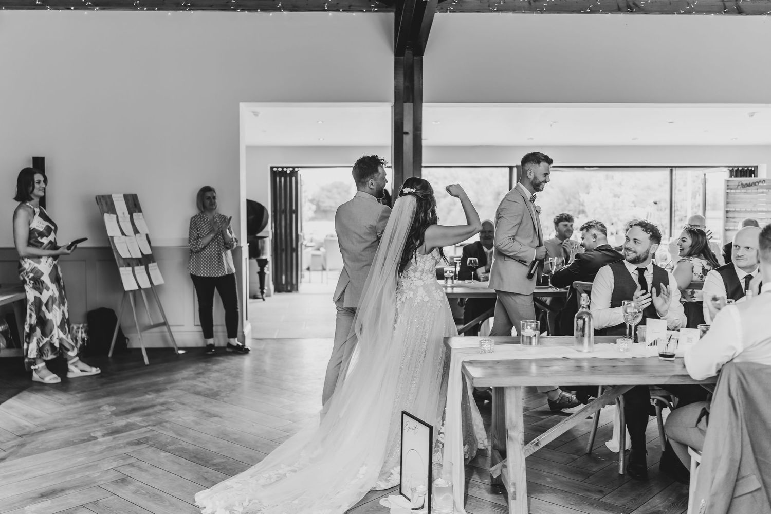 Wedding reception venue with exposed wooden beams and elegant table settings.
