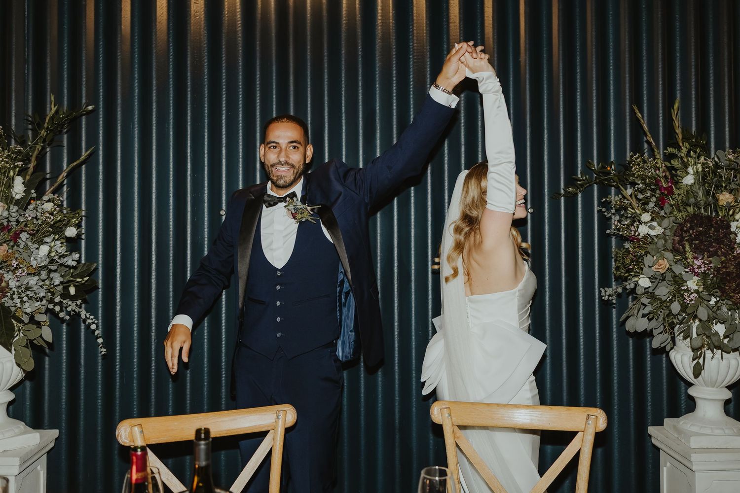 Wedding celebration in a modern venue with dark paneled walls and festive atmosphere.