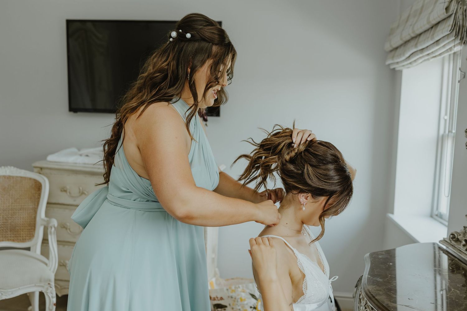 A person puts on earrings while getting ready for a wedding celebration.