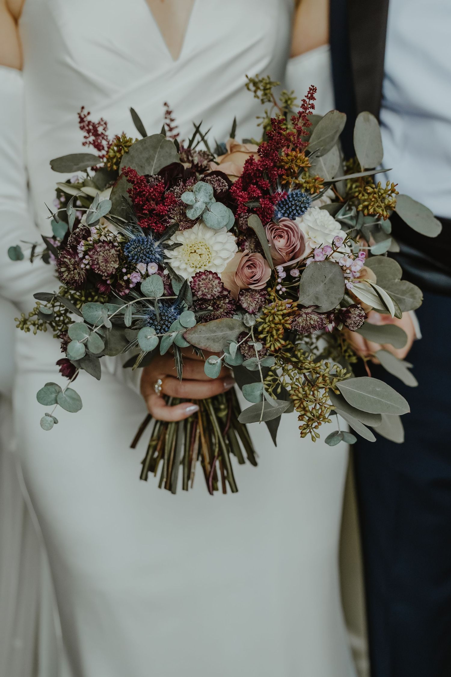 Stunning bridal bouquet with burgundy and pink flowers, roses and eucalyptus.