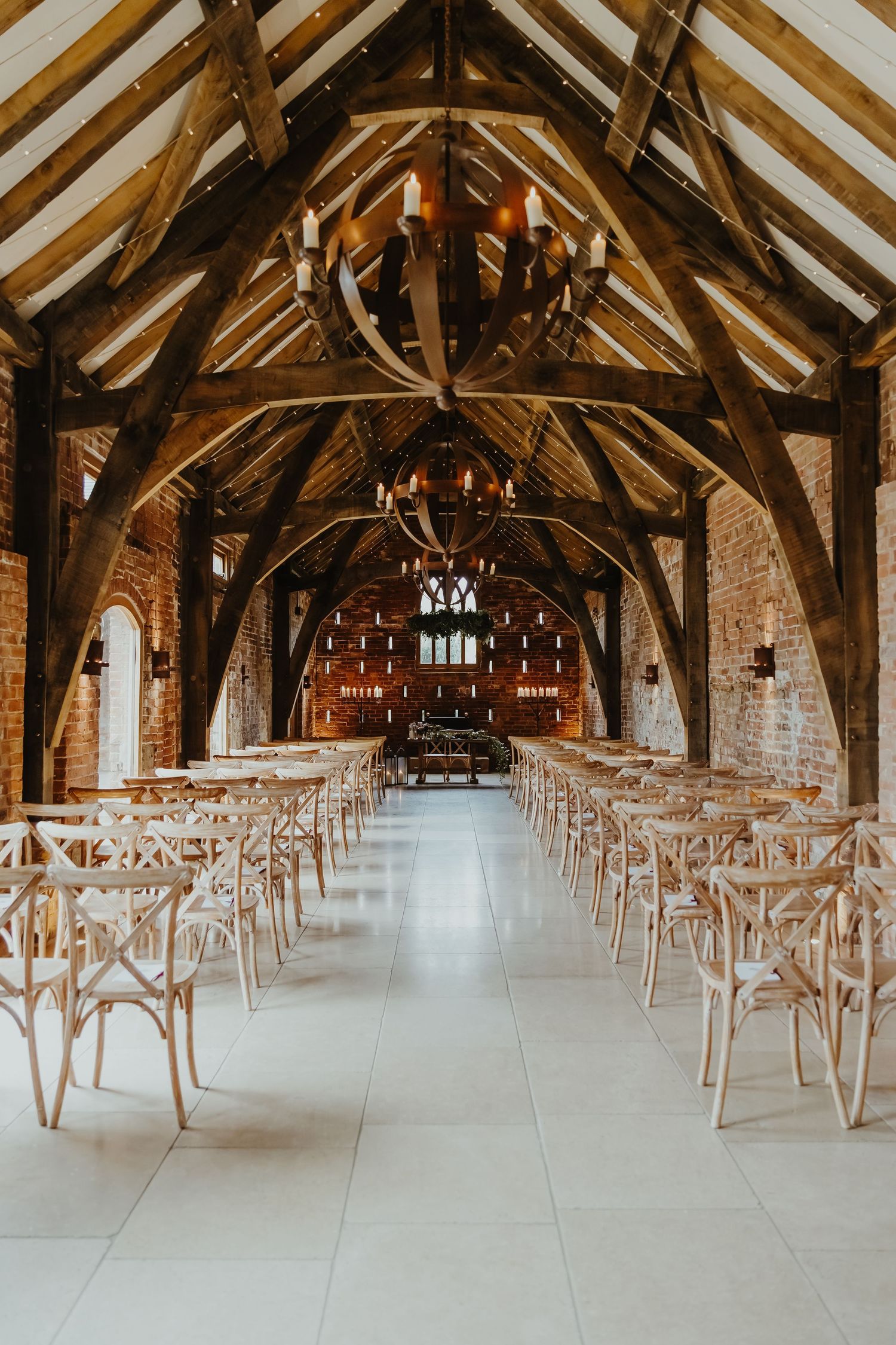 Rustic barn wedding venue with exposed wooden beams and rows of chairs for the ceremony.