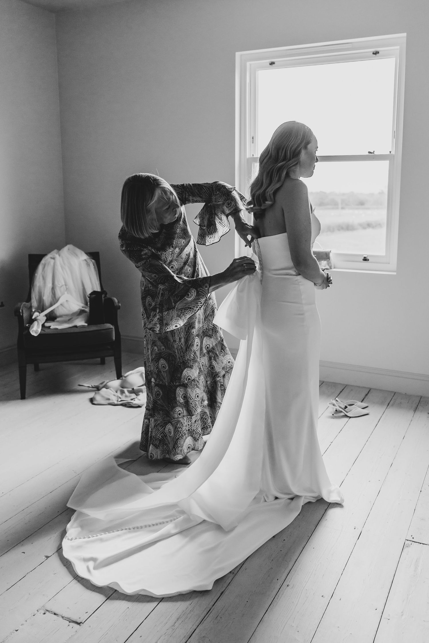 Black and white photo of wedding dress being photographed in bright room.