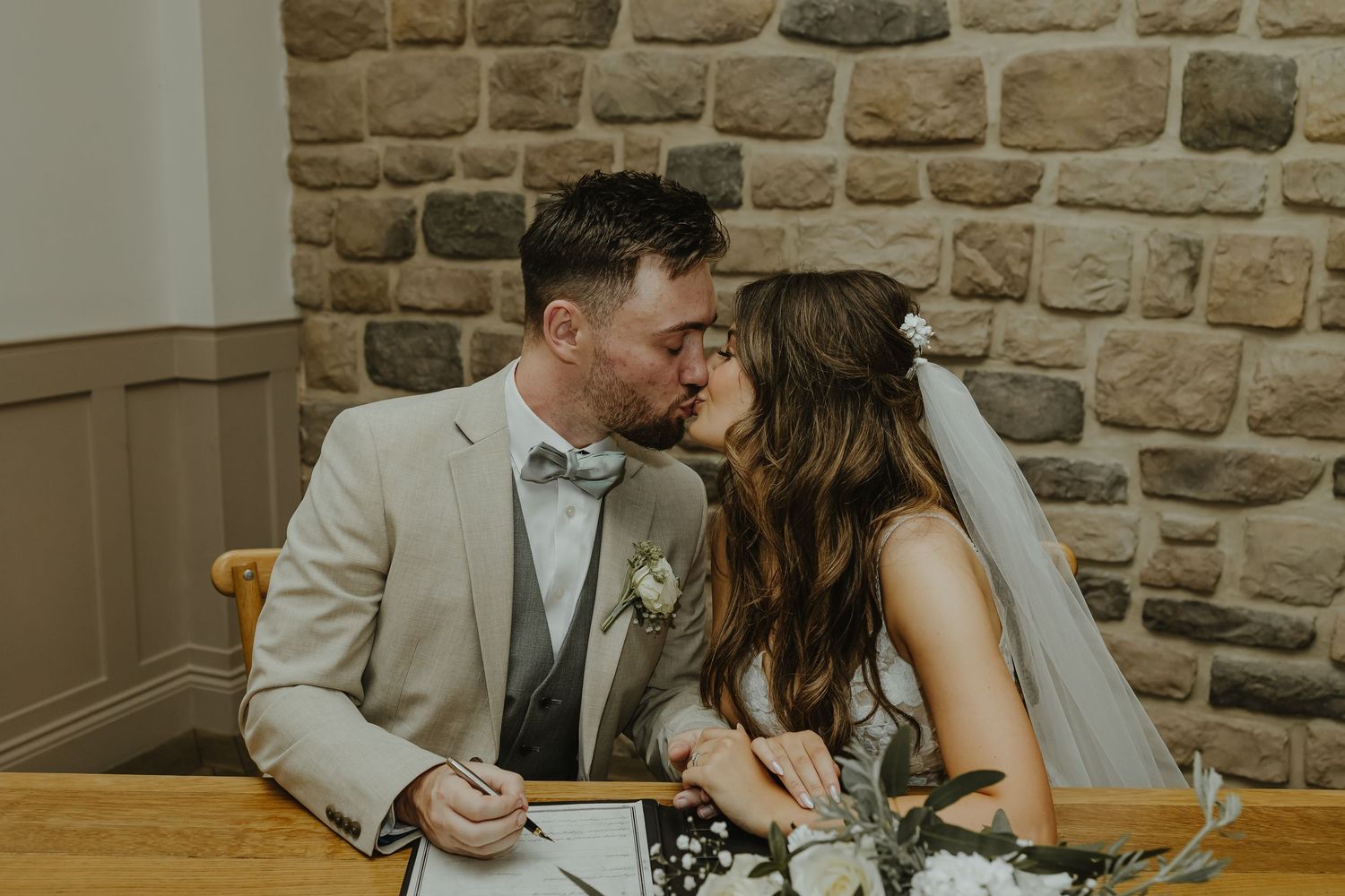 A tender moment between newlyweds sharing a kiss at their reception.