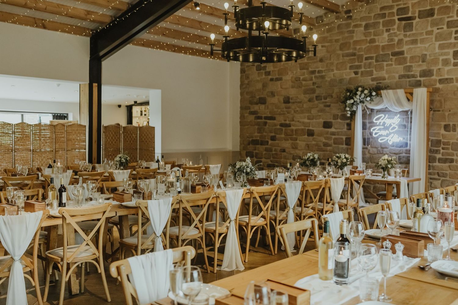 Elegant wedding reception venue with rustic brick walls and cross-back chairs.